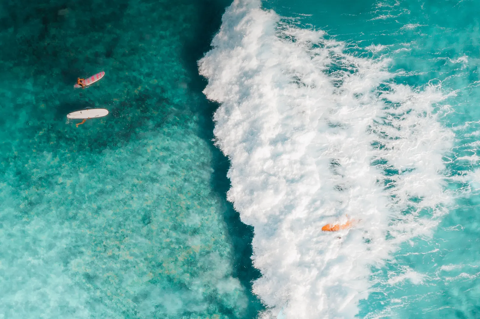 Two riderless surfboards floating in turquoise water, waiting to be used